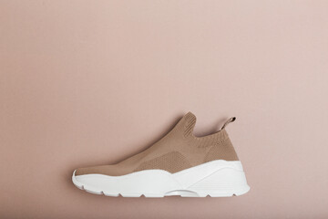 modern beige sneakers with white soles on beige background  - Image