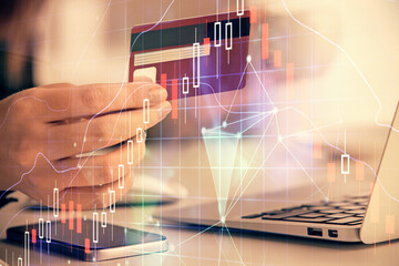 Multi exposure of woman on-line shopping holding a credit card and financial graph drawing. Stock market E-commerce concept.