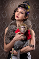 Retro female portrait in the style of 20s or 30s. A gorgeous lady is holding a little monkey.