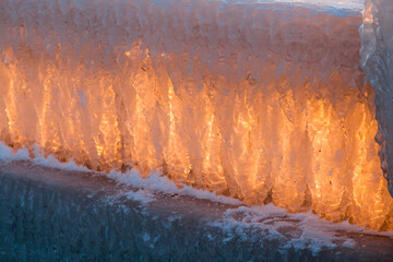 Muro de piedra helado en invierno iluminado al amanecer