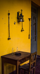 Espacios de una casa antigua, con paredes amarillas y muebles viejos