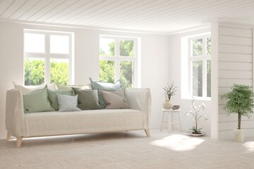 Fototapeta premium White living room with sofa and summer landscape in window. Scandinavian interior design. 3D illustration