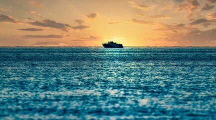 Fototapeta premium sunset in the sea with a boat