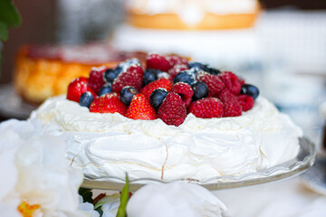 Pavlova cake with meringue, cream and red berries