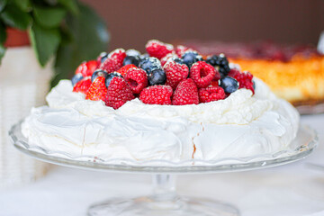 Pavlova cake with meringue, cream and red berries