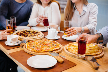 Delicious pizza close-up in a cafe during a friendly dinner.