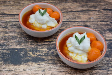 Bubur Sumsum Biji Salak, Indonesian rice flour porridge with sweet potato glutinous rice balls, served with palm sugar sauce, garnish with pandan leaf. Popular food during Ramadan