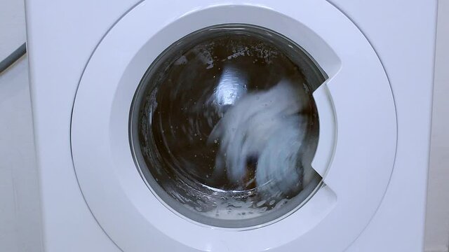 The washing machine is spinning the laundry in the drum. Big Wash. High technologies in the washing of linen.