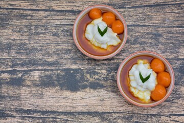 Bubur Sumsum Biji Salak, Indonesian rice flour porridge with sweet potato glutinous rice balls, served with palm sugar sauce, garnish with pandan leaf. Popular food during Ramadan