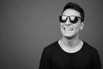 Obraz premium Young handsome Hispanic man against gray background