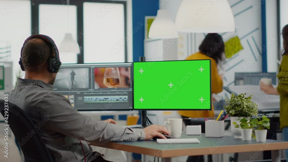 Wall mural videographer using computer with chroma key, mock up isolated display editing video and audio footag
