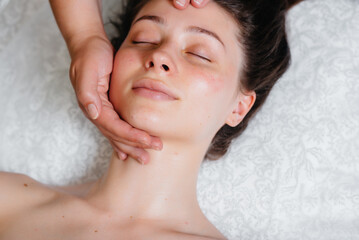 A young pretty girl is enjoying a professional head massage at the Spa. Body care. Beauty salon