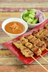 Indonesian chicken satay or Sate Ayam peanut sauce and pickles cucumber and onion