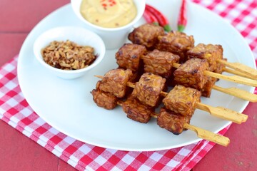 Tempeh Skewers served with spicy peanut sauce and fried onion