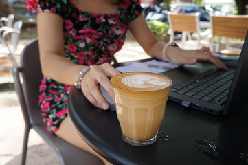 Selective focus Warm coffee in a black mug with  woman hand.