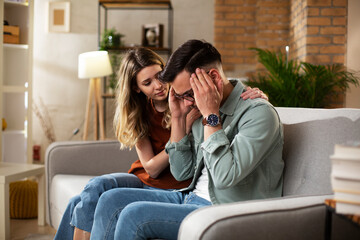 Young man having a problem. Girlfriend comforting her sad boyfriend...