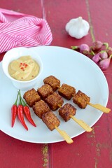 Tempeh Skewers served with spicy peanut sauce and fried onion