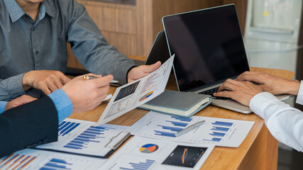 Businessman analyzes the graph of the plan on the desk with a laptop in the office.