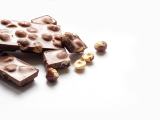 Delicious milk chocolate bars with nuts, on a white background.