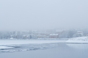 Fototapeta premium View of the Fröson Island covered with winter fog as seen from Badhusparken in Östersund