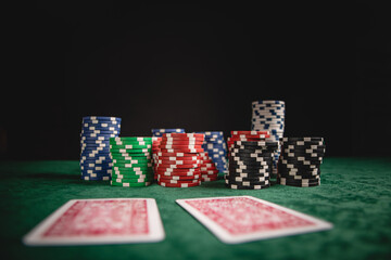 Chips and cards for poker in hand on green table