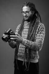 Young handsome Hispanic man with dreadlocks in black and white