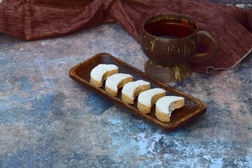 Putri Salju or crescent-shaped cookies coated with powdered sugar. Traditional Indonesian cookies to celebrate Eid al Fitr. Served with tea. 