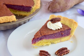 Homemade purple sweet potato pie with whipped cream and pecans