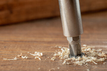 Self-tapping screw screwed into a wooden board close-up. Screw for wood