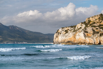 Fototapeta na wymiar Stormy sea with waves and rocks on background. Buggerru beach in Sardinia, Italy.