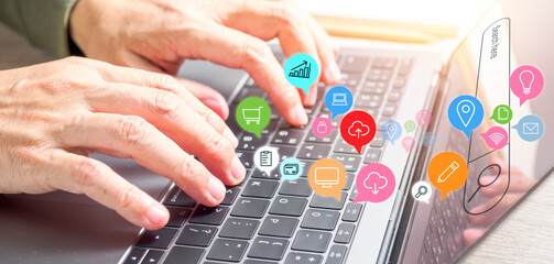 Close-up of male hands using laptop computer with online icons. Online shopping