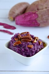 Mashed purple sweet potato with pecan nuts and maple syrup