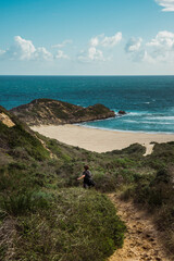 Woman hiking along the Robberg Nature Reserve coastline in South Africa. September 2019