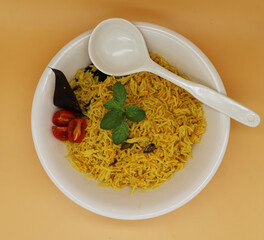 Cooked turmeric jasmine rice with powdered curcumin or Haldi, Indian food, indian basmati rice homemade with tomato and Cardamom.