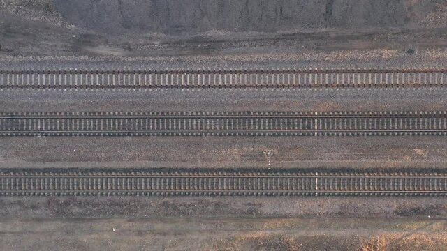 Railroad rails and sleepers, top view drone footage - Smooth Flight over empty railway tracks. Drone Flying Over Railway Tracks, Top View Panning Shot