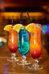 Blue and orange non-alcoholic cocktail decorated with an orange slice on the bar. Close-up, selective focus