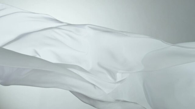 White transparent silk fabric flowing by wind, super slow motion