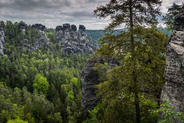 View from viewpoint of Bastei Bridge in Saxon Switzerland Germany to the town at the mountain on a cloudy day