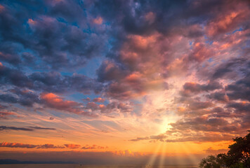 Beautiful cloudscape and dramatic sunset over mountain and sea.