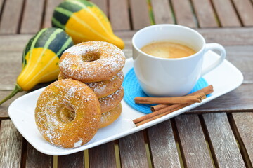 Stack of pumpkin donuts with cinnamon sugar on dark wooden background