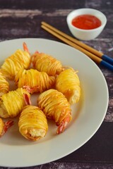 Deep fried prawns wrapped in potato strings served with chili sauce