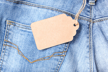 Craft tag, label on blue denim jeans background, copy space