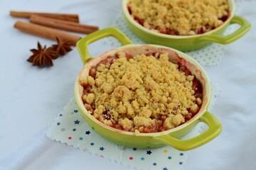 Plum crumble with spices on white background. Summer crispy fruit dessert. Tasty breakfast

