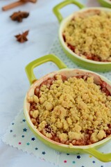 Plum crumble with spices on white background. Summer crispy fruit dessert. Tasty breakfast

