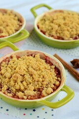 Plum crumble with spices on white background. Summer crispy fruit dessert. Tasty breakfast
