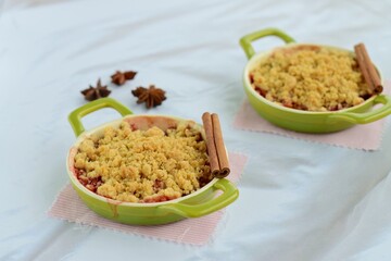 Plum crumble with spices on white background. Summer crispy fruit dessert. Tasty breakfast
