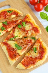 pizza with tomato sauce, mozzarella and basil leaves on wooden board