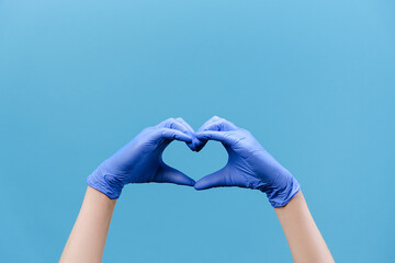 Close up of male hands in medical protection gloves making heart symbol as a way to show thank...