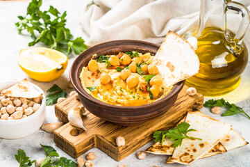 Hummus with olive oil and paprika at light kitchen table.
