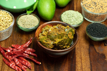 Mango Pickel or Homemade Mango Pickle in a wooden bowl, selective focus, isolated on wooden background